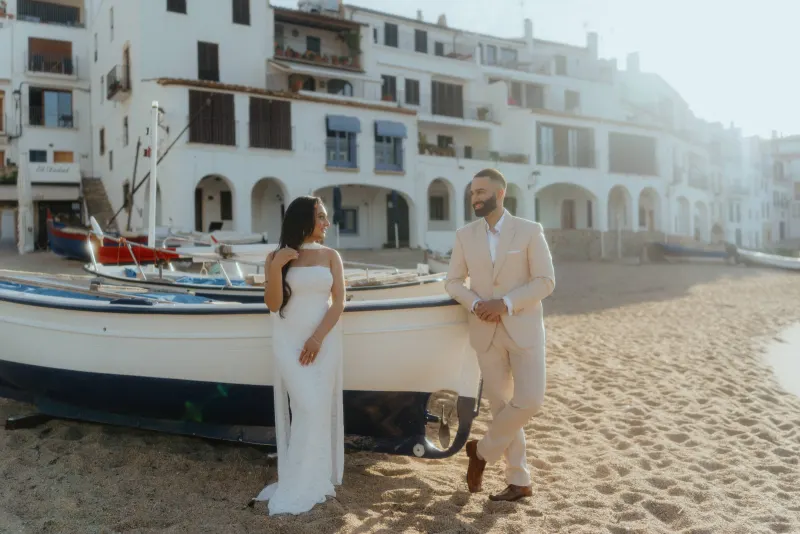 Couple sharing a joyful moment on a sandy beach in Spain during a surprise proposal photoshoot.