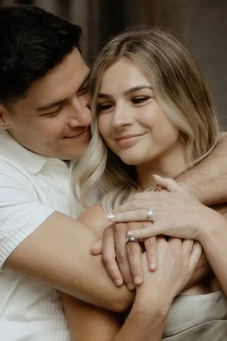 Couple sharing a loving embrace, hands intertwined and smiling softly during a Vacation Portraits session in Barcelona.