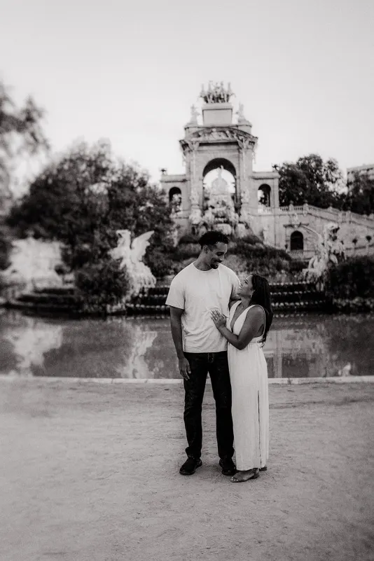 Couple sharing a loving gaze in front of the grand fountain at Parc de la Ciutadella during an engagement photoshoot.