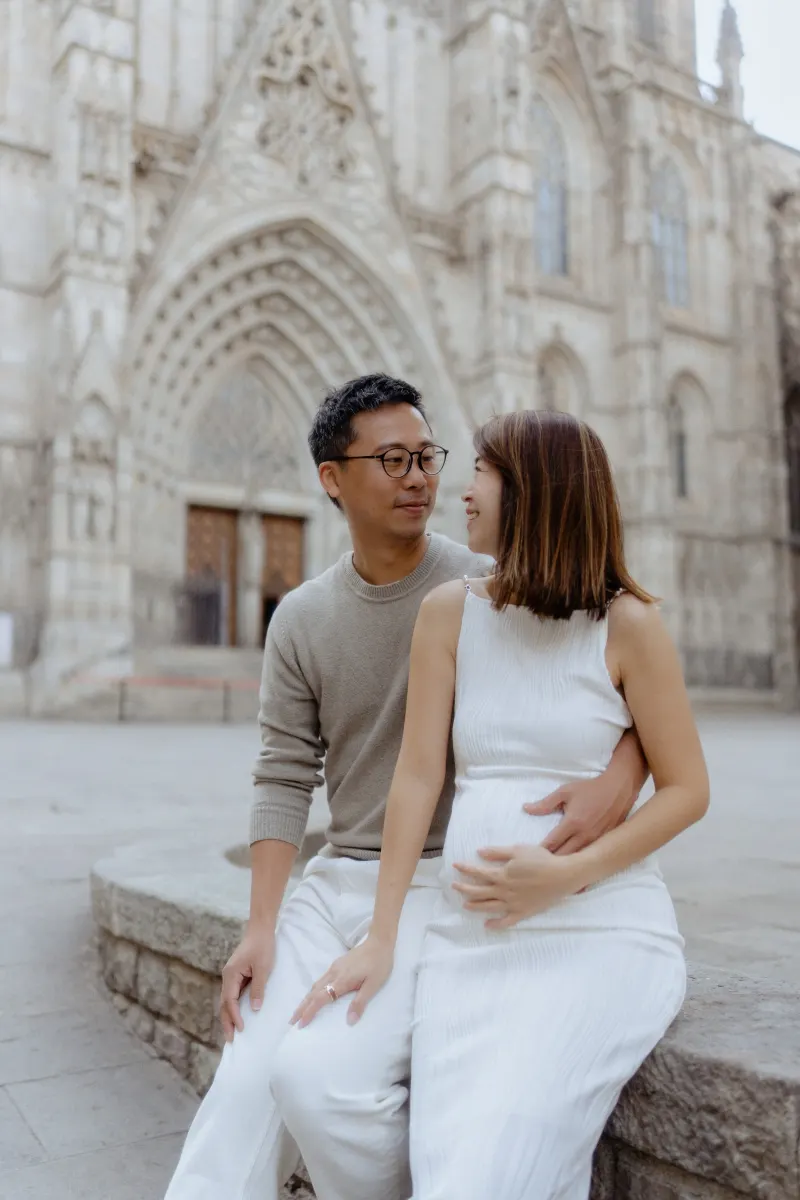 Couple sharing a loving moment during a Vacation Portraits photoshoot in front of Barcelona’s cathedral.