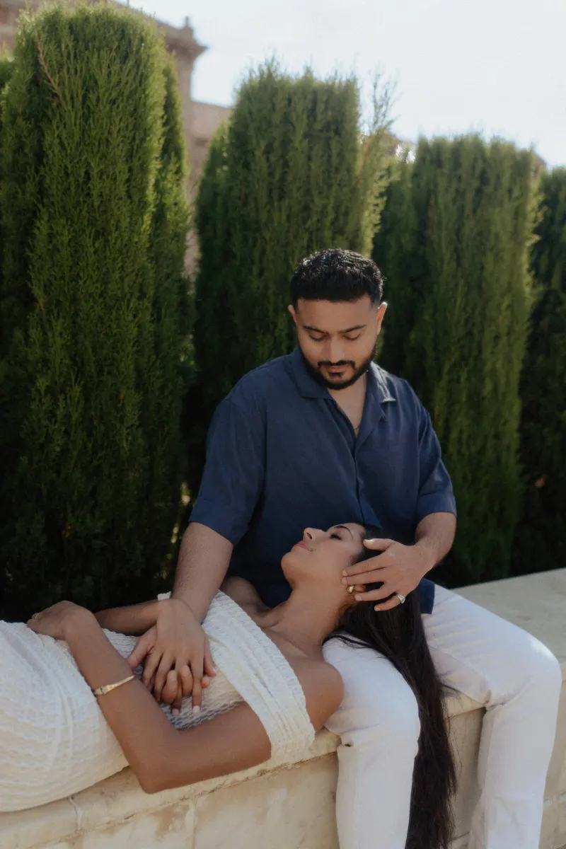 Couple sharing a peaceful, intimate moment as she rests in his lap during a couples & engagements photoshoot outdoors.