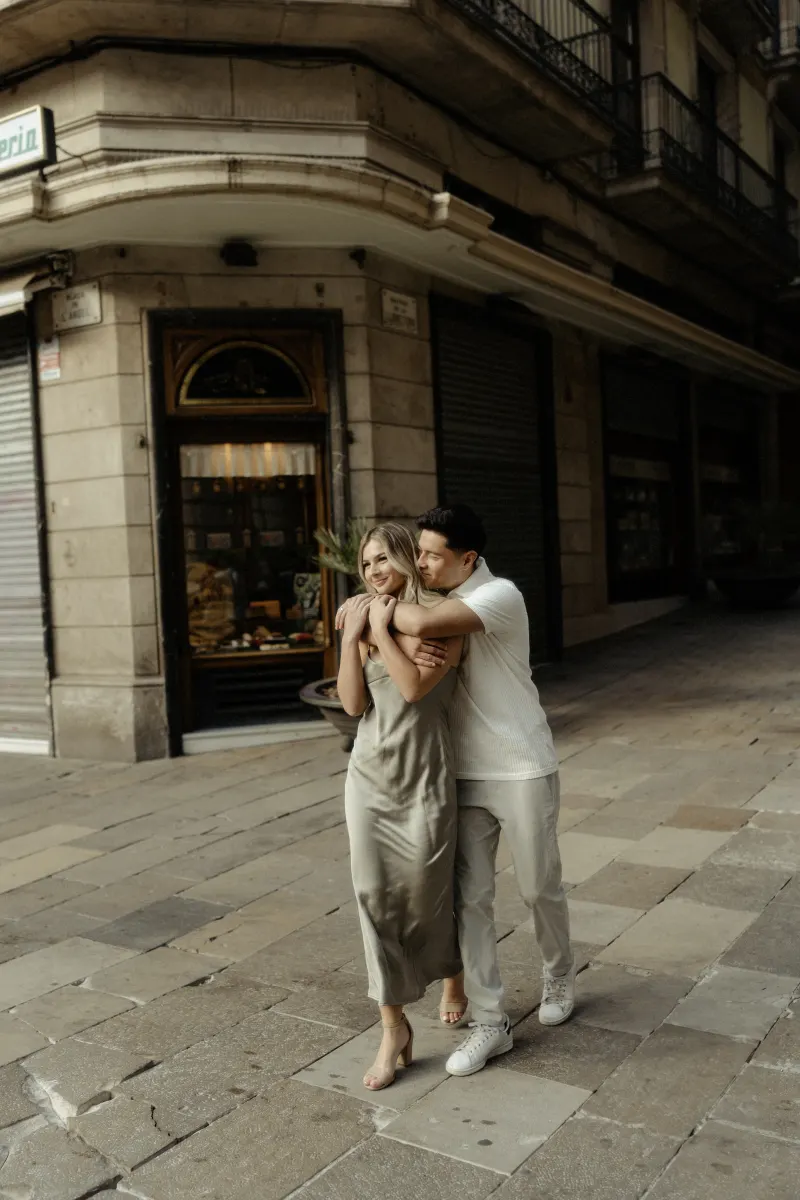 Couple sharing a playful embrace while strolling through Barcelona’s streets during a Vacation Portraits photoshoot.