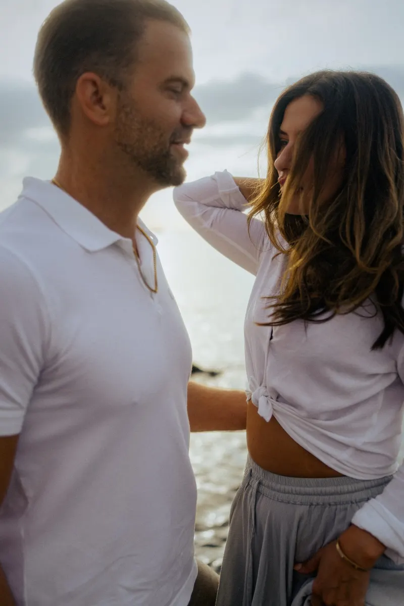 Couple sharing a quiet, affectionate moment by the ocean during a couples & engagements photoshoot.