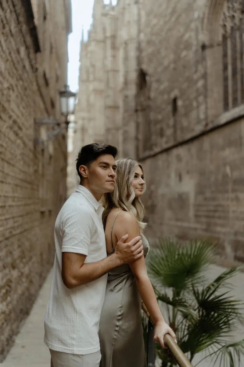 Couple sharing a quiet, affectionate moment in a historic Barcelona alley during their Vacation Portraits photoshoot.