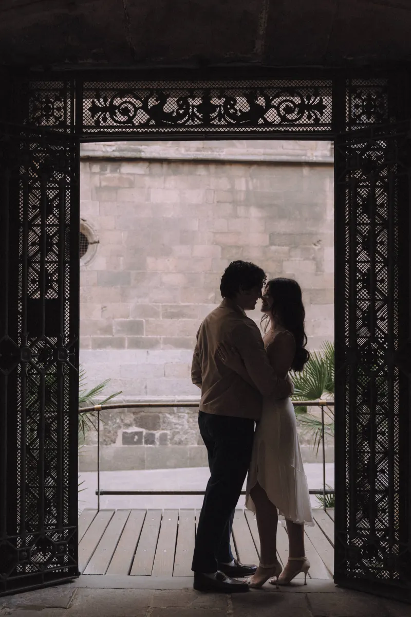 Couple sharing a quiet embrace in a historic archway, captured during a couples & engagements photoshoot.