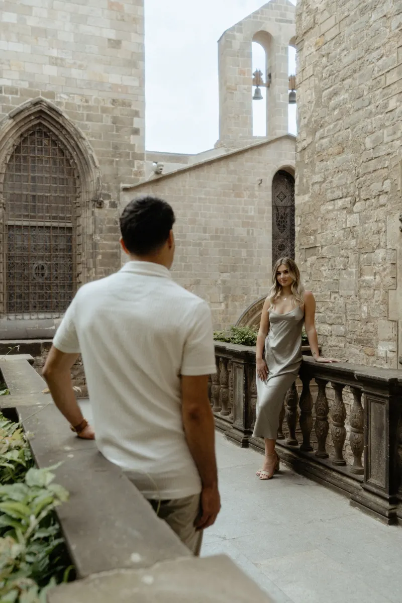 Couple sharing a quiet moment in a historic Barcelona courtyard during their Vacation Portraits photoshoot.