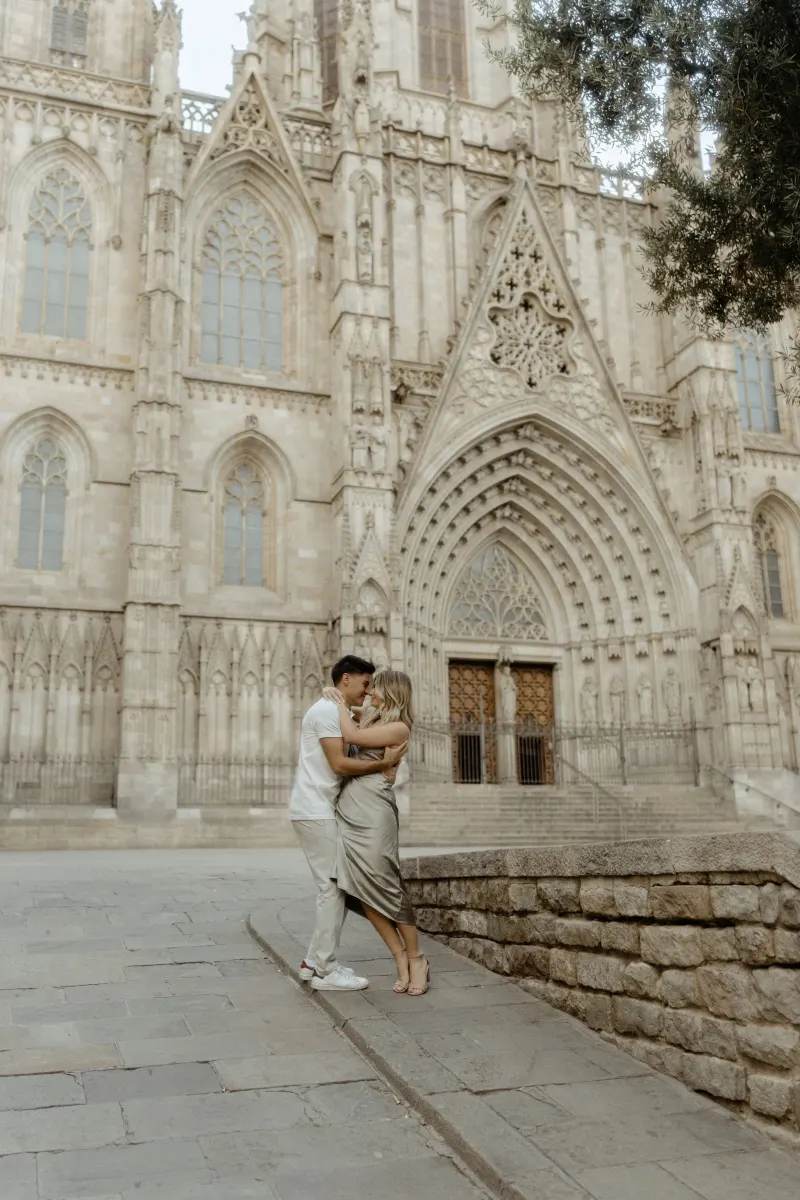 Couple sharing a romantic embrace outside Barcelona’s cathedral during a Vacation Portraits photoshoot.