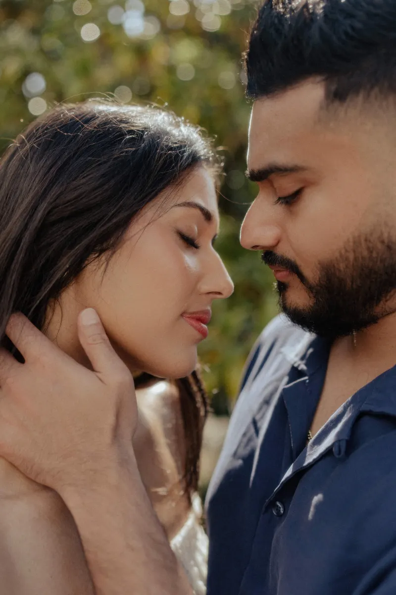 Couple sharing a tender, intimate moment outdoors during a couples & engagements photoshoot, eyes closed in gentle embrace.