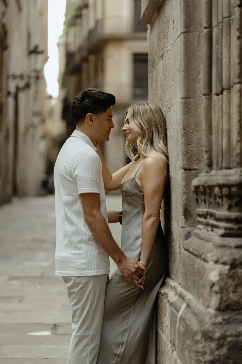 Couple sharing a tender moment against a stone wall in Barcelona’s Gothic Quarter during a Vacation Portraits session.