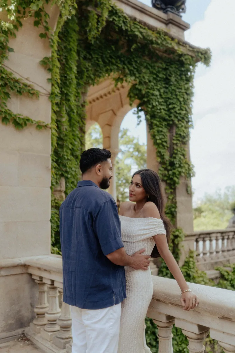 Couple sharing an intimate moment on a vine-covered balcony during a romantic couples & engagements photoshoot in Barcelona.