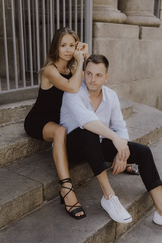 Couple sits close on stone steps, sharing a calm, thoughtful moment during a couples & engagements photoshoot.