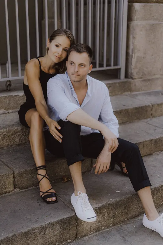 Couple sits close on stone steps, sharing a peaceful moment during a couples & engagements photoshoot in the city.