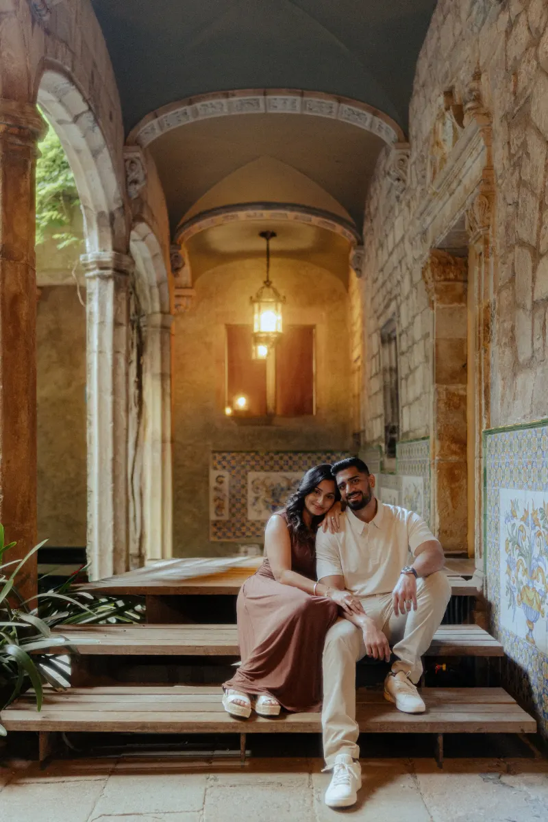 Couple sits close together on stone steps, sharing a peaceful moment during their couples & engagements photoshoot.