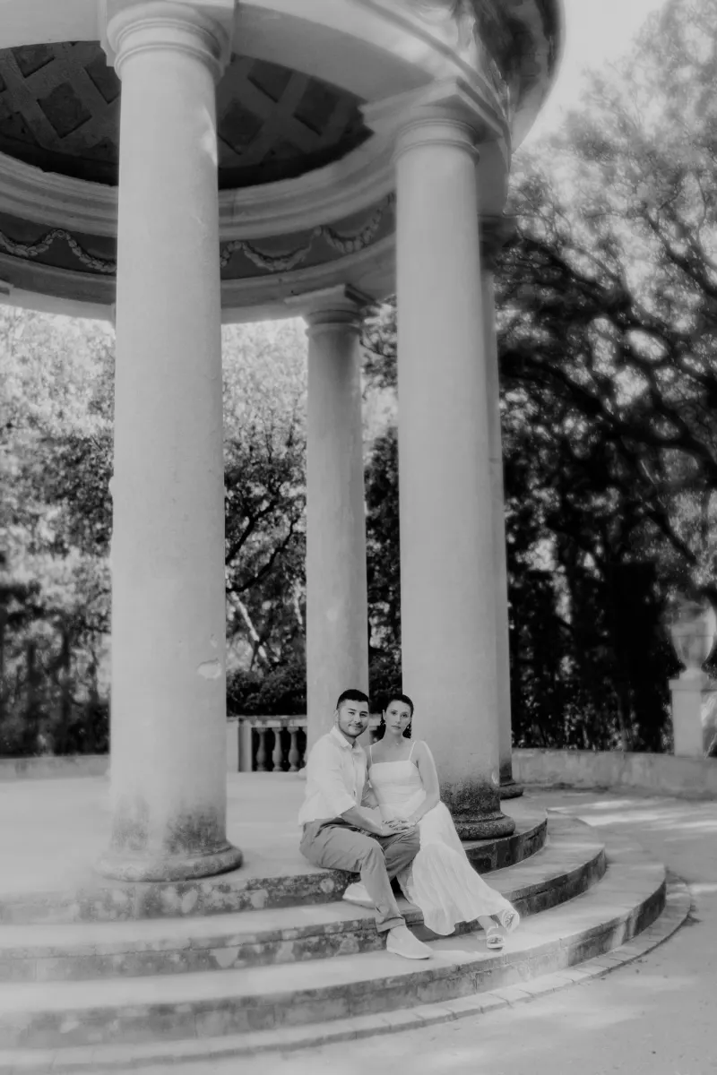 Couple sits together on pavilion steps, holding hands and sharing a quiet moment during a couples & engagements session.
