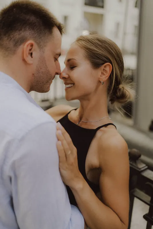 Couple smiling with foreheads touching, sharing a romantic moment during a couples & engagements photoshoot outdoors.