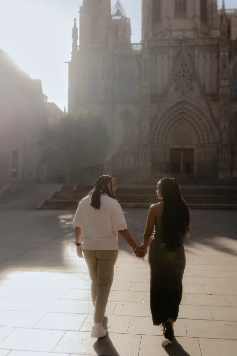 Couple walks hand in hand toward Barcelona Cathedral, sharing a quiet moment during a surprise proposal session.