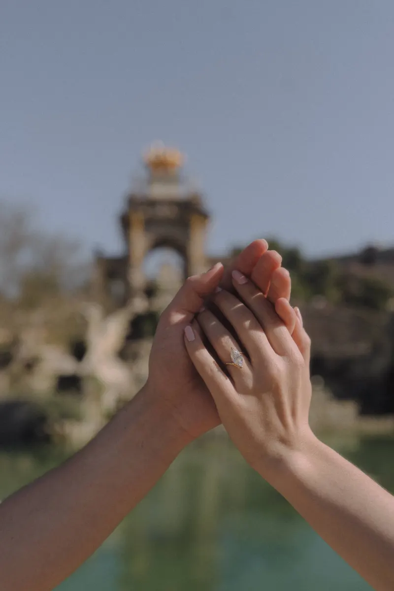 Couple’s hands gently intertwined, engagement ring sparkling in sunlight at Parc de la Ciutadella couples photoshoot.