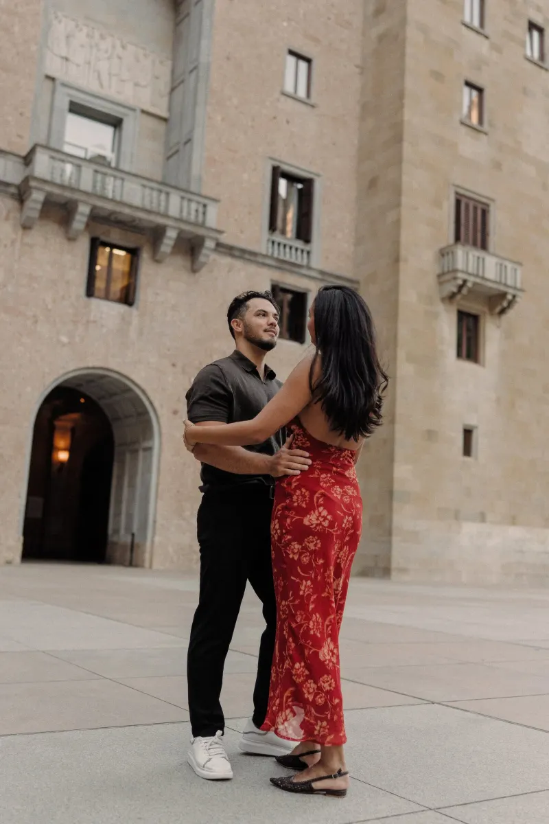 Dan and Sydney dance together against the warm stone façade of Montserrat monastery.