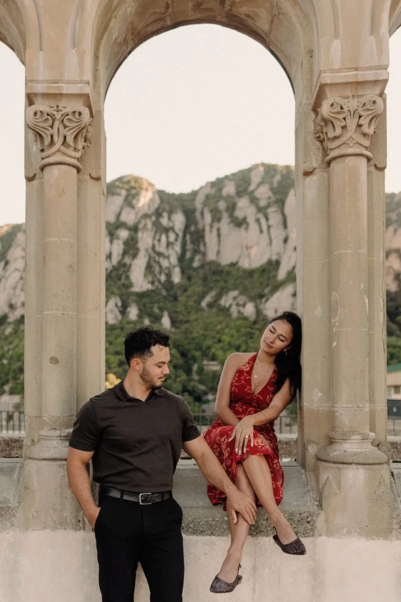 Dan and Sydney laugh together beneath the historic arcade at Montserrat monastery.