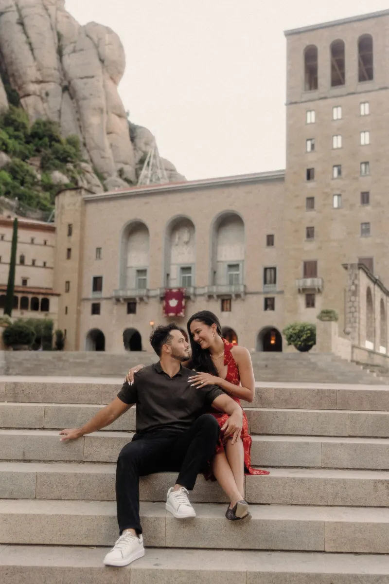 Dan and Sydney sit close together on broad stone steps in Montserrat.