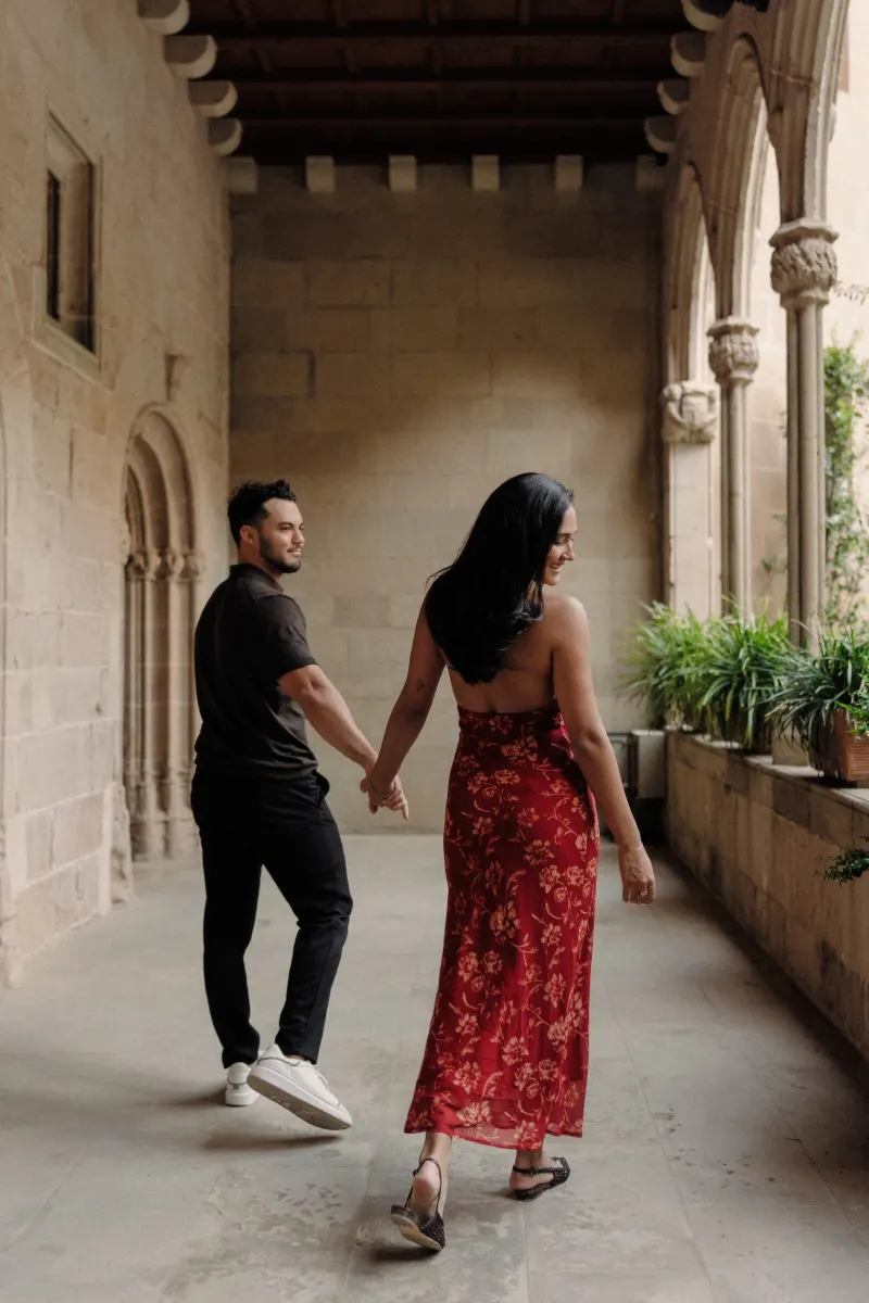 Dan and Sydney stroll together through the softly lit arcade at Montserrat.