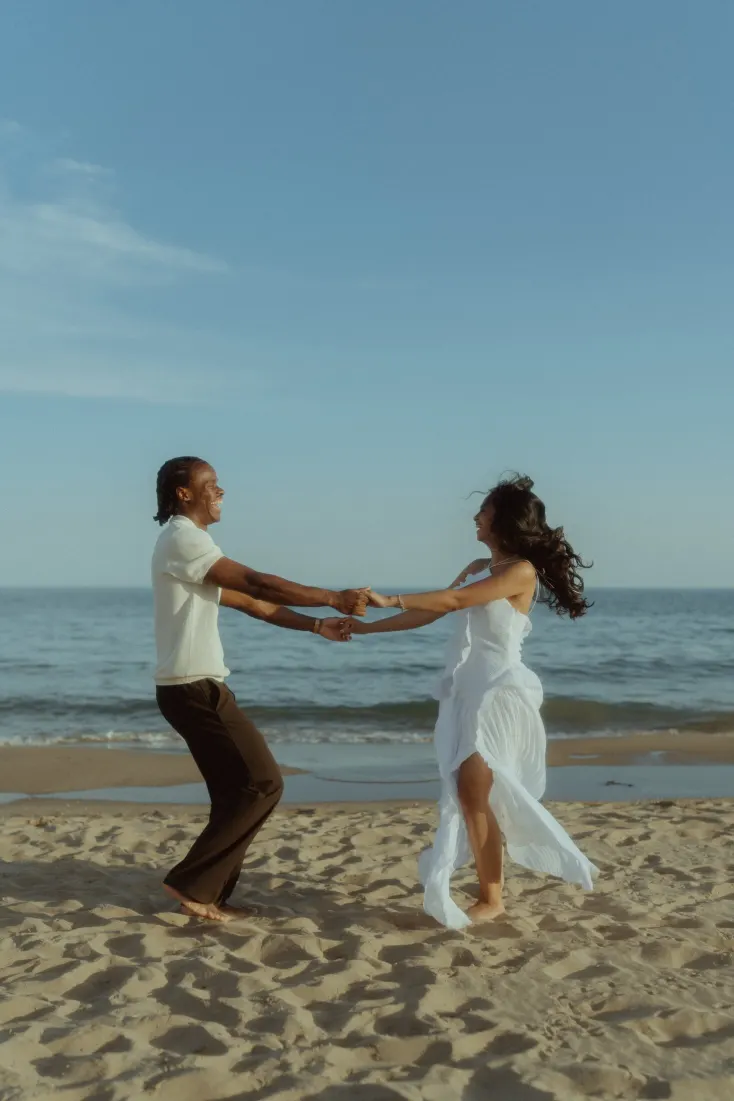 Dexter and Cheryl dance playfully by the Mediterranean during their Castelldefels engagement photoshoot.