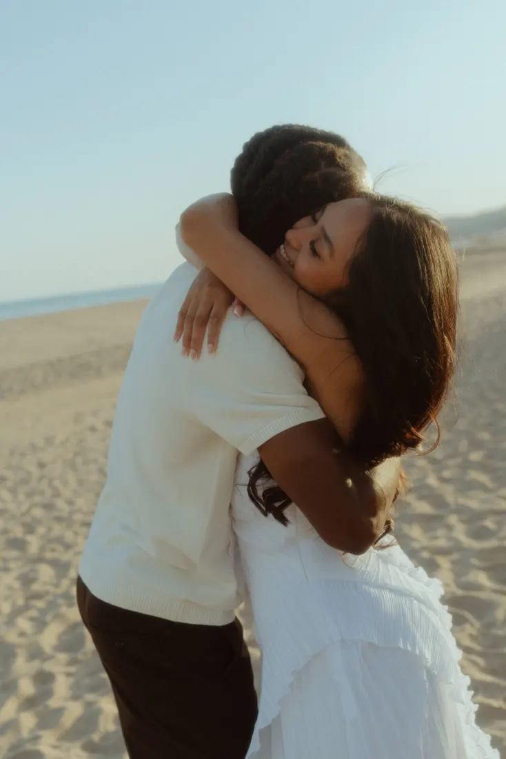 Dexter and Cheryl kiss on the beach after their surprise proposal near Barcelona.
