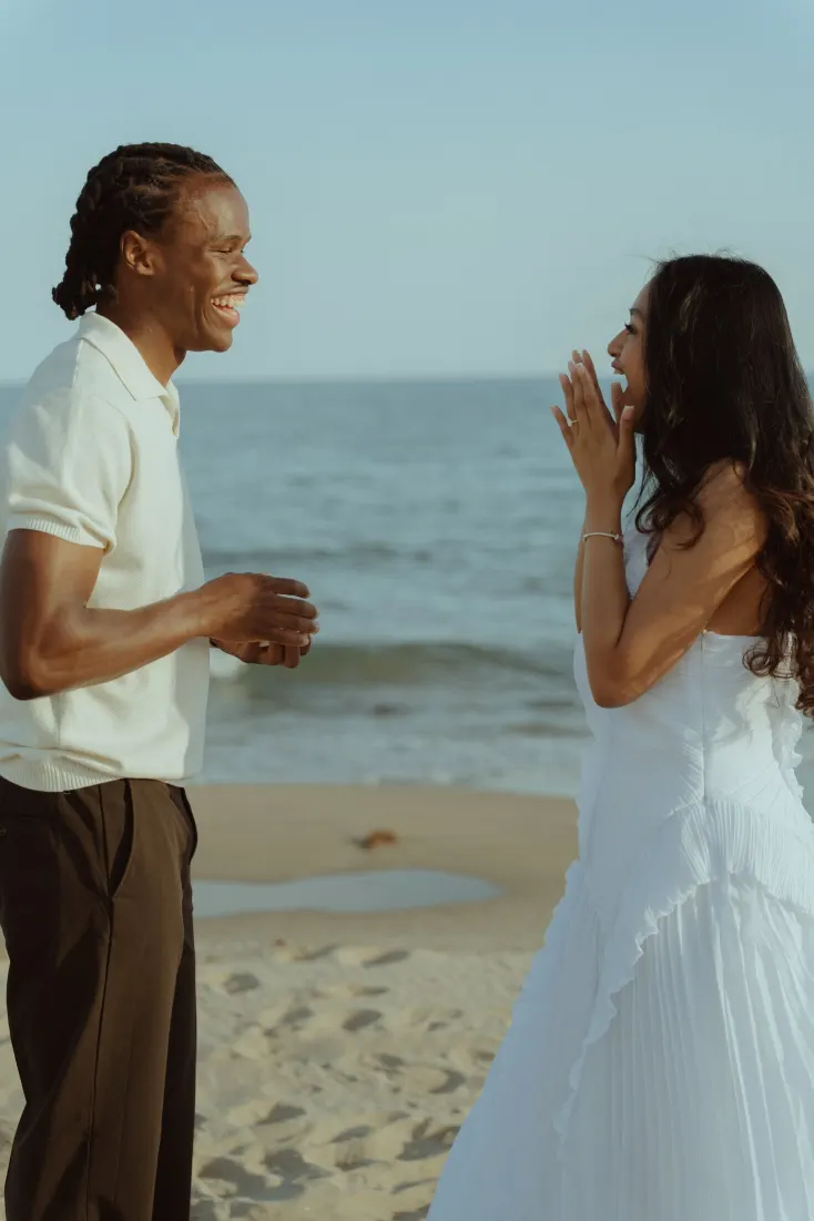 Dexter and Cheryl laugh together after she says yes during their Castelldefels Beach proposal.