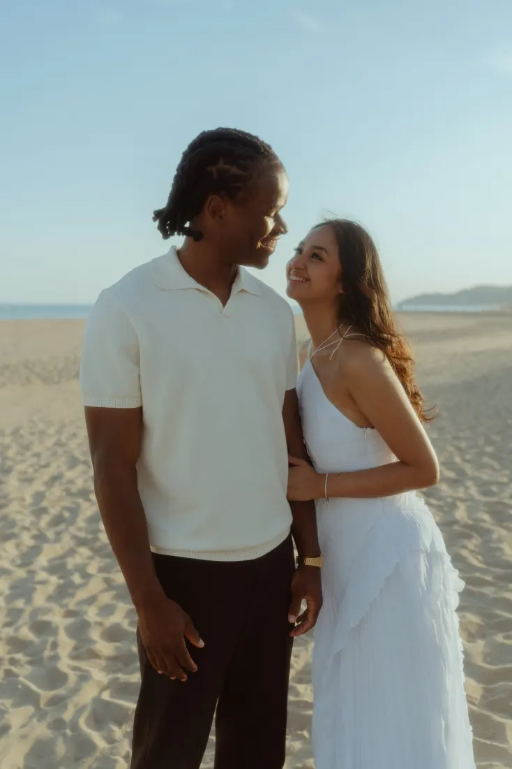 Dexter and Cheryl smile together at the end of their Castelldefels Beach proposal photoshoot.