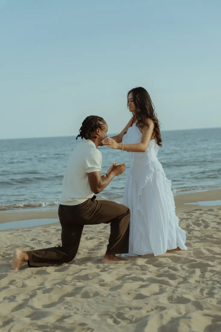 Dexter proposes to Cheryl on the sand with the Mediterranean Sea behind them at Castelldefels Beach.