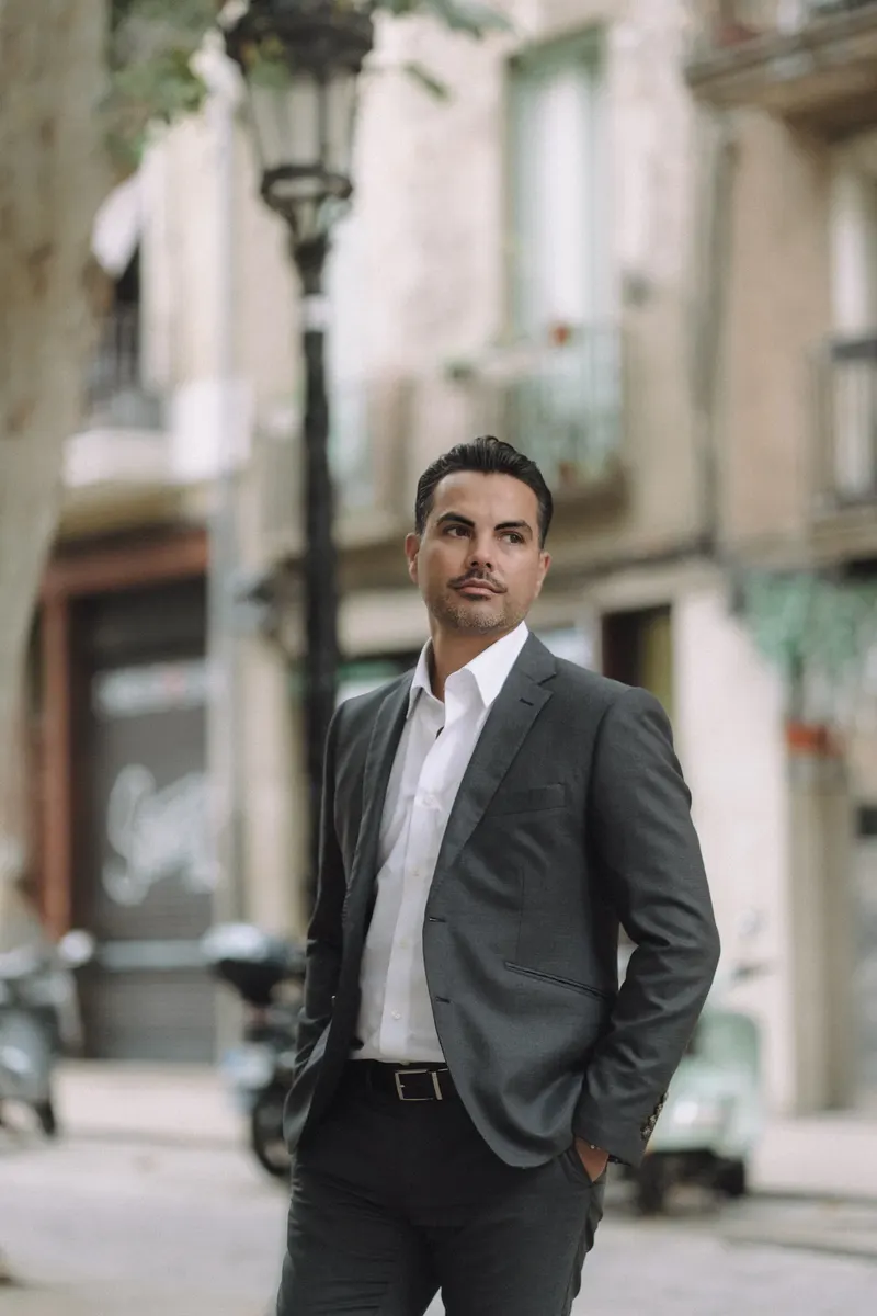 Edgar poses alone on a quiet historic street at the end of the couple photoshoot.