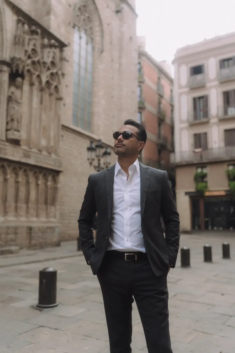 Edgar poses in sunglasses against the warm stone architecture of the Gothic Quarter.