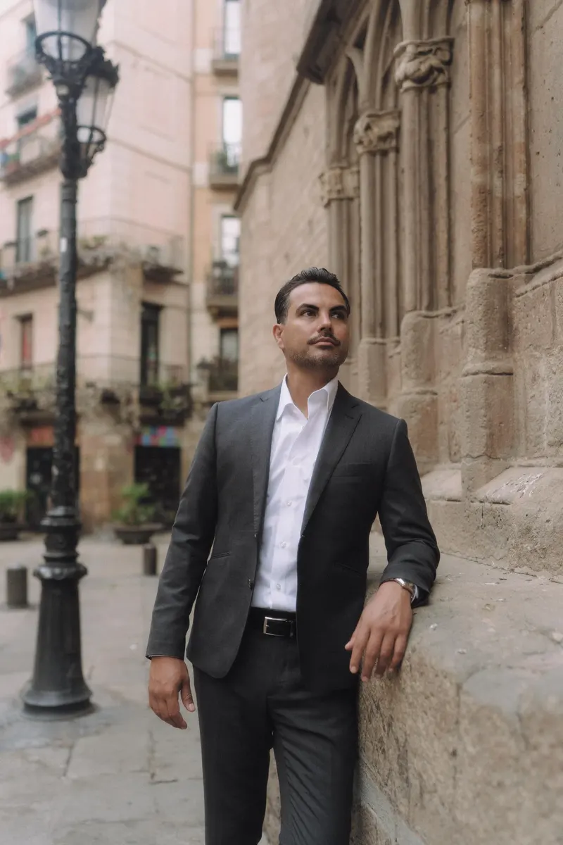 Edgar walks beside a Gothic church during an individual portrait in Barcelona.