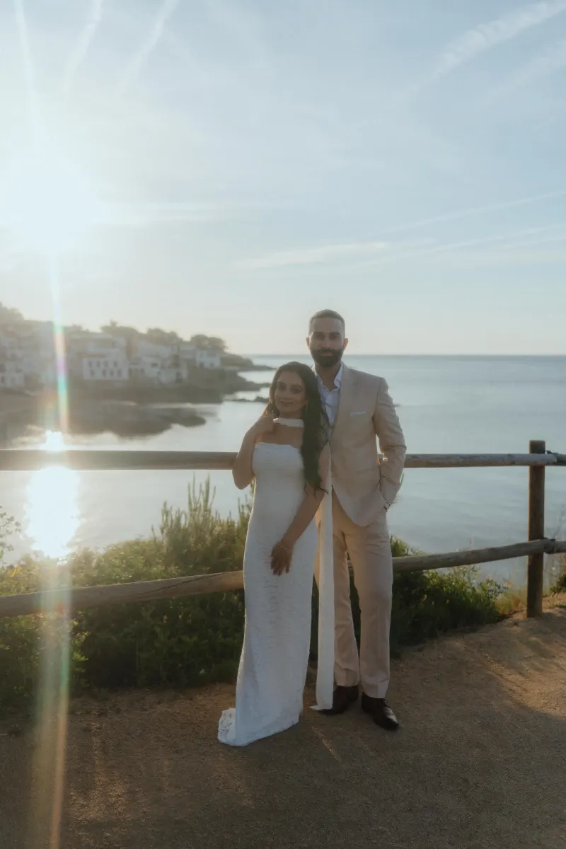 Engaged couple poses by the seaside at golden hour, capturing a joyful moment from their surprise proposal photoshoot.