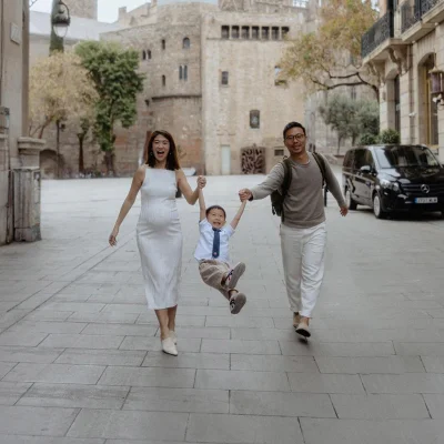Family photoshoot Barcelona – Silas and Kate walking with their child through Gothic Quarter street