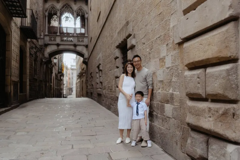 Family smiles together during a Vacation Portraits photoshoot in a quiet Gothic Quarter street in Barcelona.