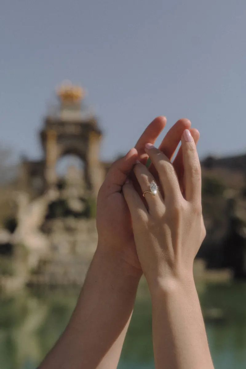 Hands intertwined, engagement ring sparkling in sunlight during a couples & engagements photoshoot at Parc de la Ciutadella.