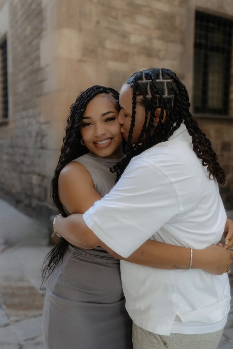 Happy couple embraces and shares a sweet kiss in Barcelona’s Gothic Quarter during a surprise proposal photoshoot.