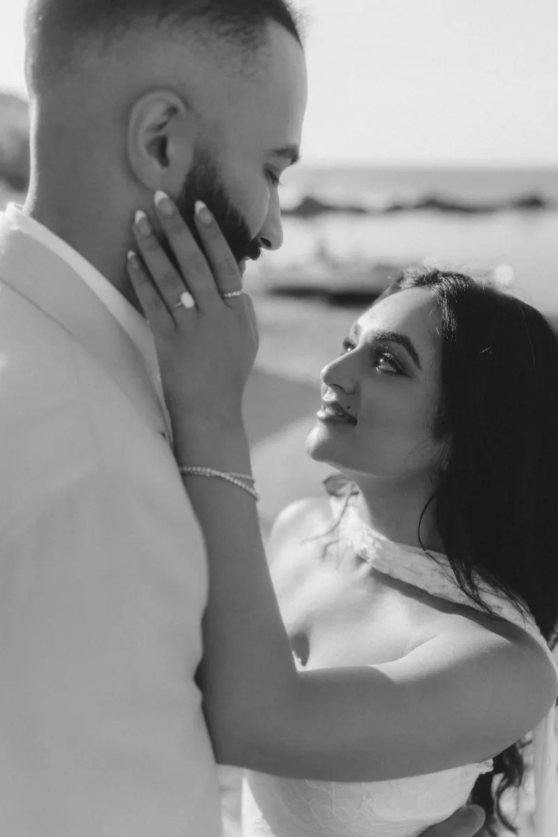 Joyful couple shares an intimate moment by the beach after a surprise proposal photoshoot.