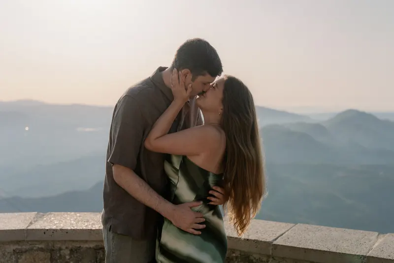 Megan rests her hand against Tim's cheek as they kiss.