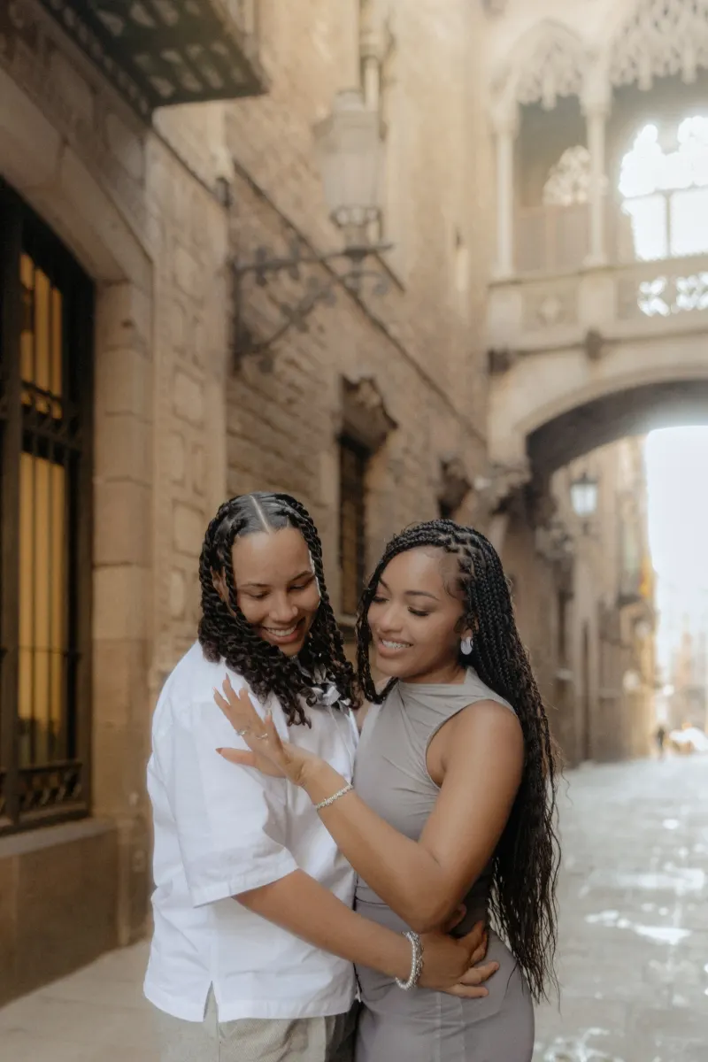 Newly engaged couple smiles and admires the ring during a surprise proposal photoshoot in Barcelona’s Gothic Quarter.