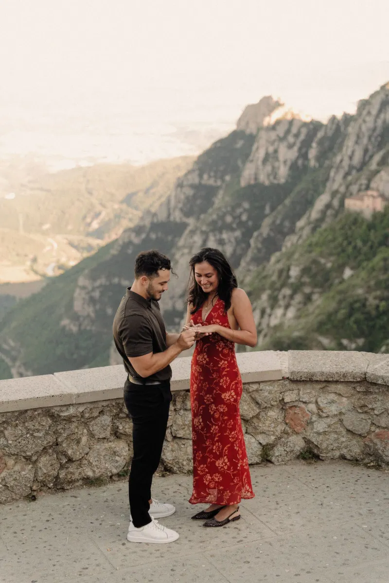 Newly engaged Dan and Sydney hold hands beside the stone viewpoint wall in Montserrat.