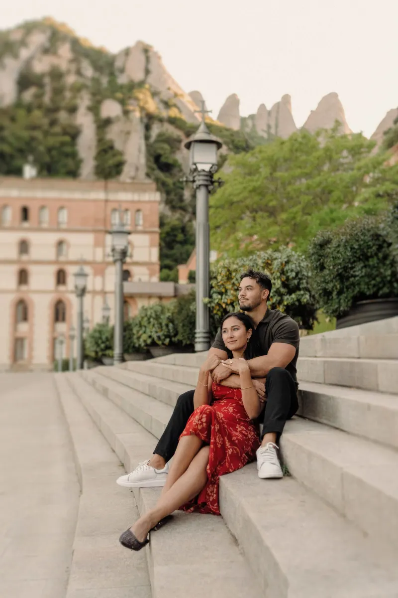 Newly engaged Dan and Sydney relax together on the monastery steps in Montserrat.