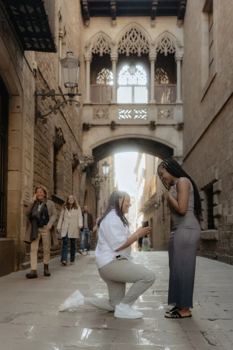 One partner proposes on one knee in Barcelona’s Gothic Quarter, capturing a joyful surprise proposal moment.