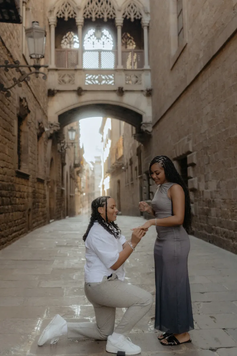 One partner proposes on one knee, slipping a ring onto their loved one’s finger in Barcelona’s Gothic Quarter.