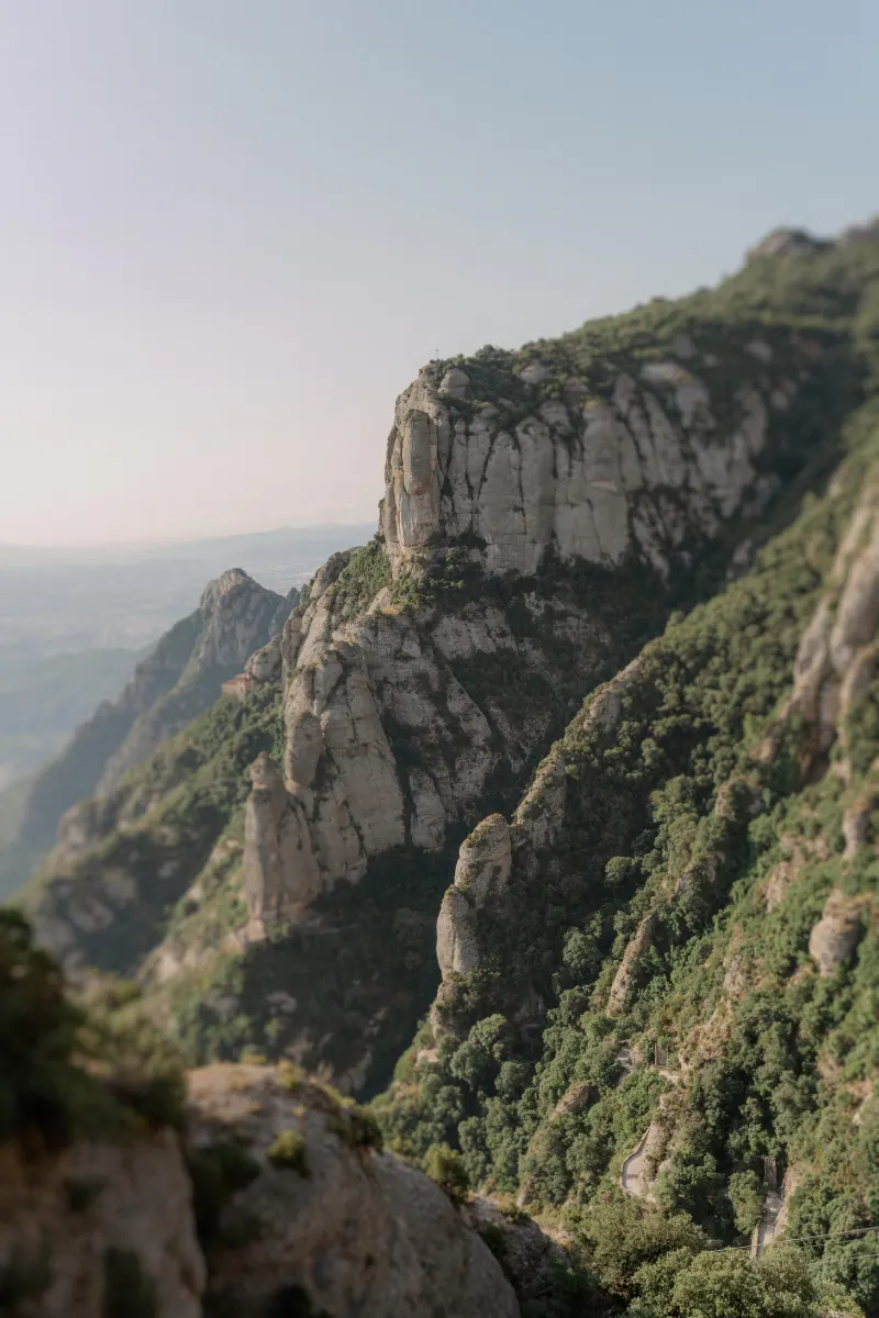 Rocky Montserrat cliffs rise above green mountain slopes.