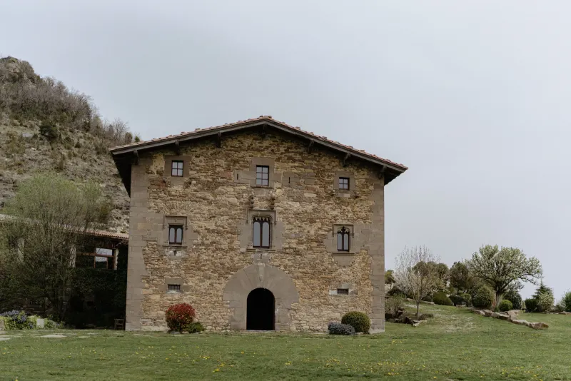 Rustic stone house surrounded by greenery, perfect backdrop for a surprise proposal photoshoot in the countryside.