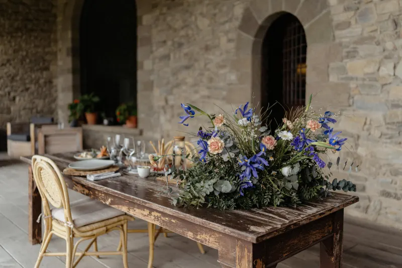Rustic table set with elegant florals and dinnerware, styled for a countryside surprise proposal photoshoot.