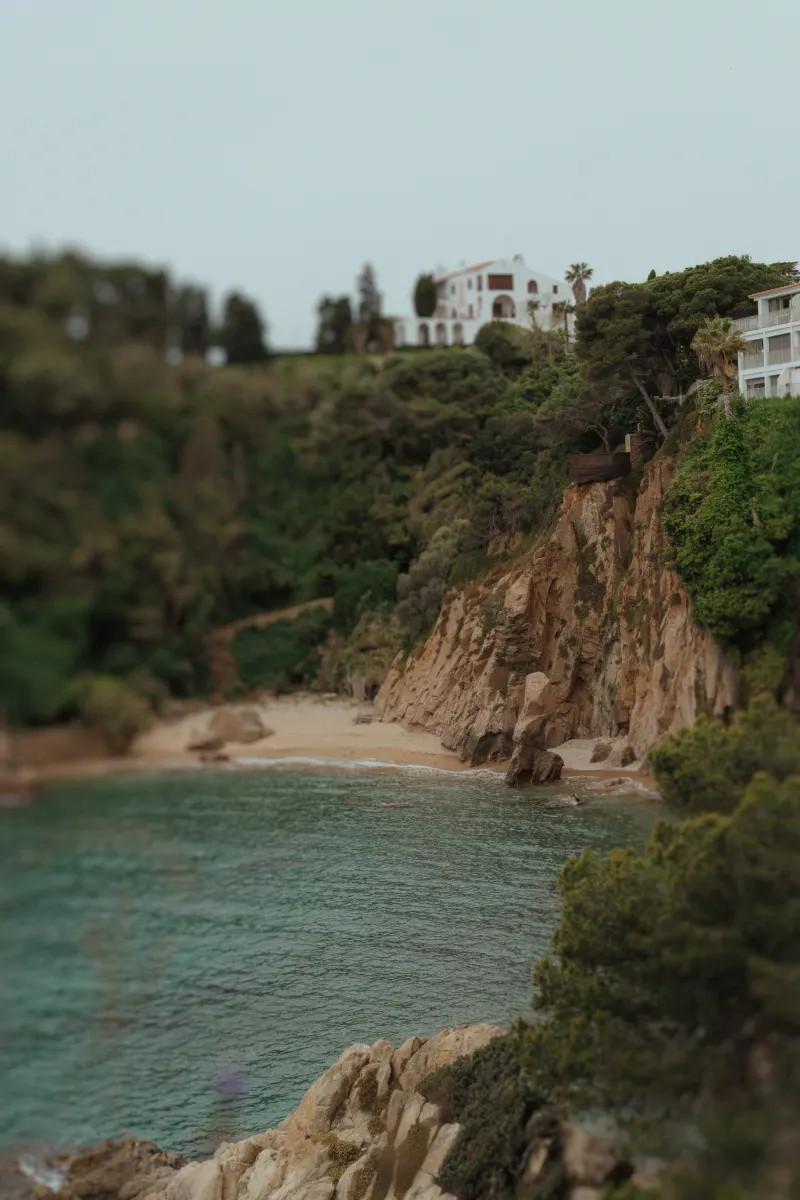 Secluded beach cove beneath lush cliffs, perfect for an intimate surprise proposal photoshoot by the sea.