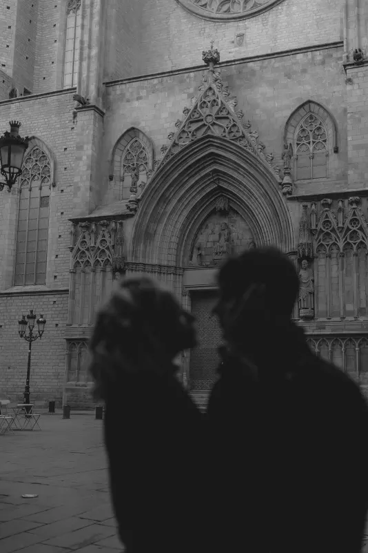 Silhouetted couple shares a quiet moment in front of a historic Barcelona cathedral during a couples & engagements photoshoot